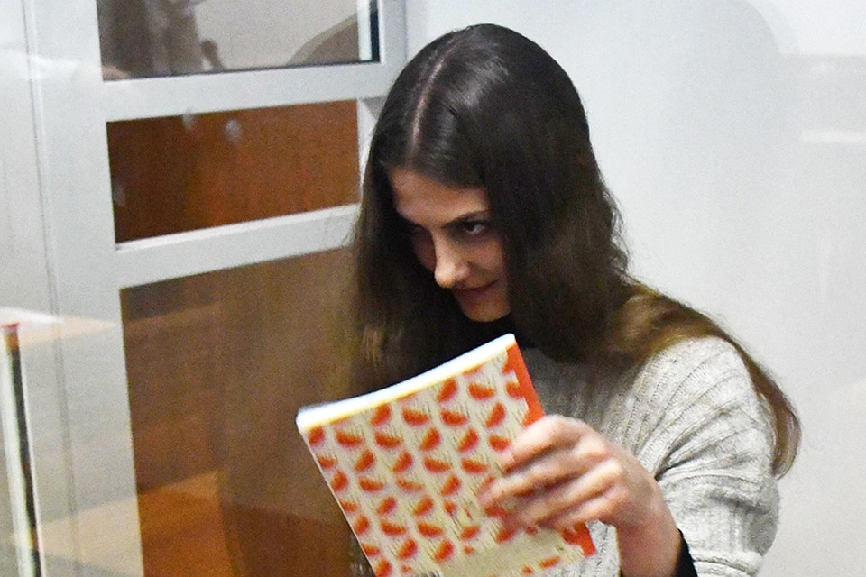 В «клетке» с пуленепробиваемыми стёклами Дария поначалу прячет лицо от камер за какой-то тетрадкой