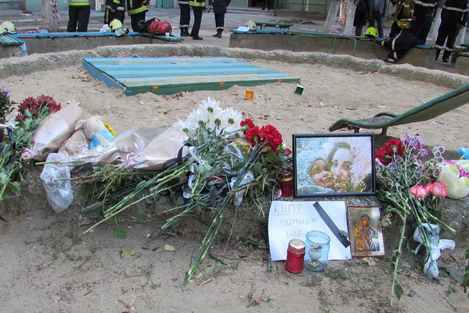 Люди приносят цветы и свечи во двор дома где произошел взрыв