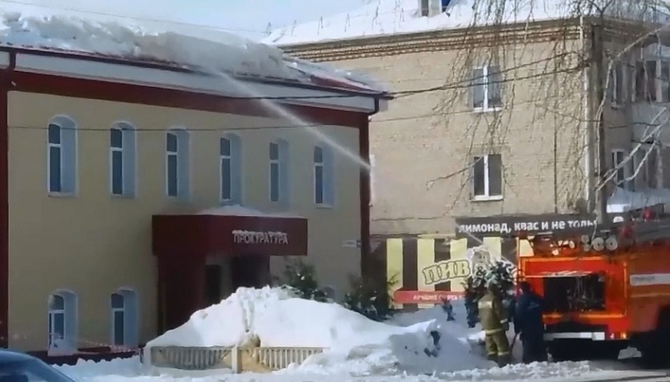 Кадр из видео: бригада пожарных поливает из брандспойта крышу здания прокуратуры.