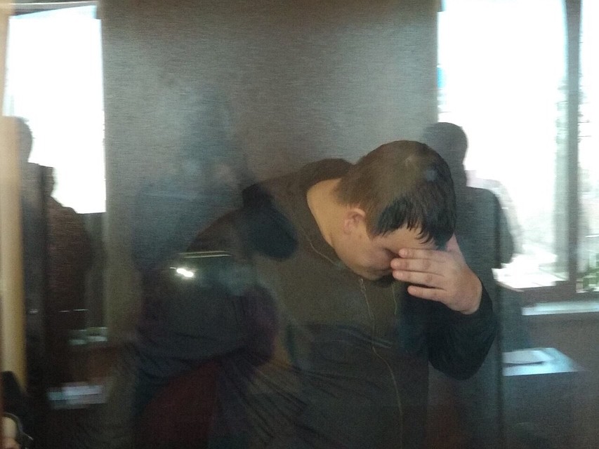 Обвиняемый прячет лицо и натягивает на голову капюшон