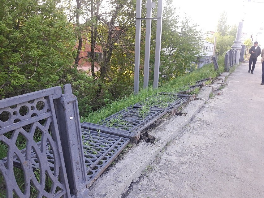 В одном месте моста ограждение лежит на земле.