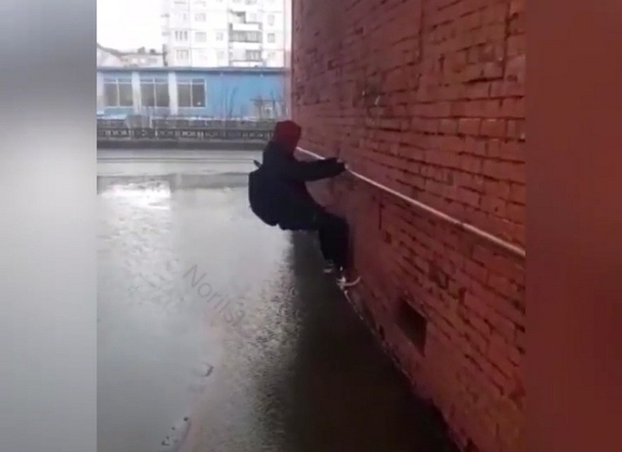 Парень карабкается по стене, чтобы преодолеть гигантскую лужу Фото: соцсети