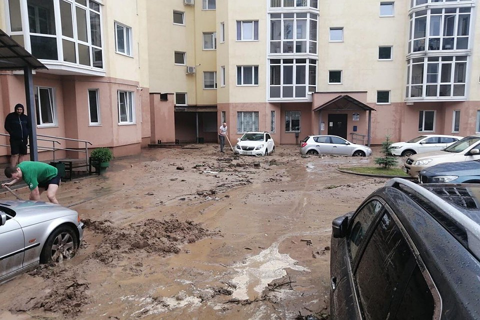 В Могнлеве после ливня автомобили во дворе одного из домов увязли в грязи, пришлось откапывать лопатами. Фото: Вконтакте, группа "Это Могилев, детка!"
