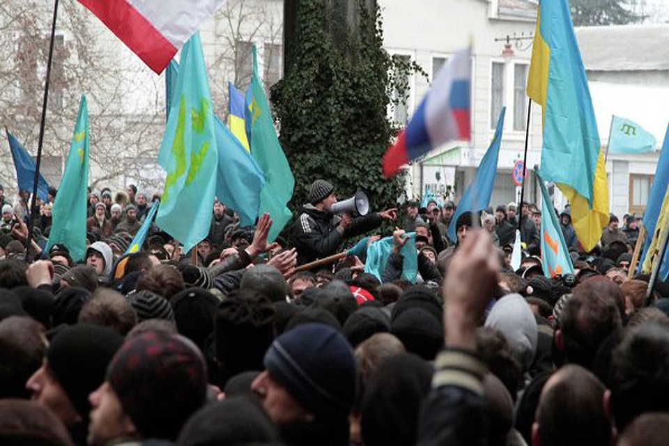 В настоящее время площадь перед зданием администрации полностью заполнена людьми, которые держат в руках российские флаги