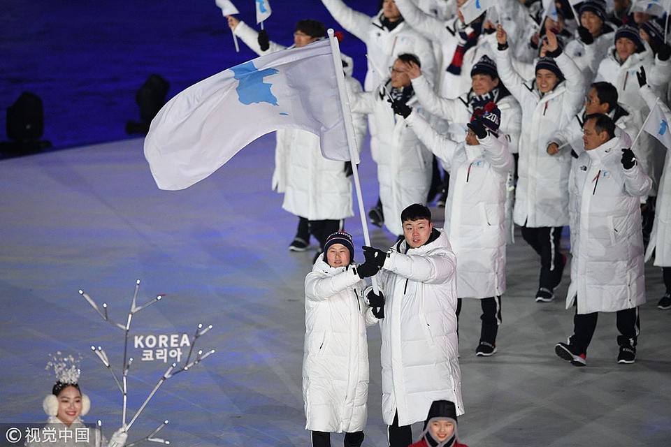 Команды Южной и Северной Кореи прошли объединенной командой под одним флагом с силуэтом корейского полуострова.