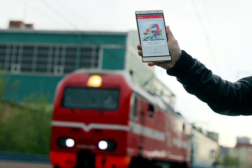 На экране - картинка с девочкой в наушниках, перебегающей пути перед поездом и надпись: «Плеер, наушники, капюшон и железная дорога несовместимы! Они мешают заметить поезд!» Фото: Виктория МИНАЕВА
