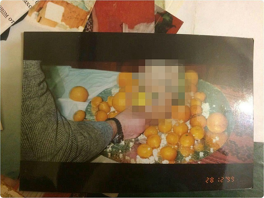 На одной из карточек на усыпанном мандаринами блюде лежит приготовленная голова человека