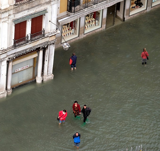 Туристы гуляют по площадям Венеции по колено в воде. Фото: REUTERS