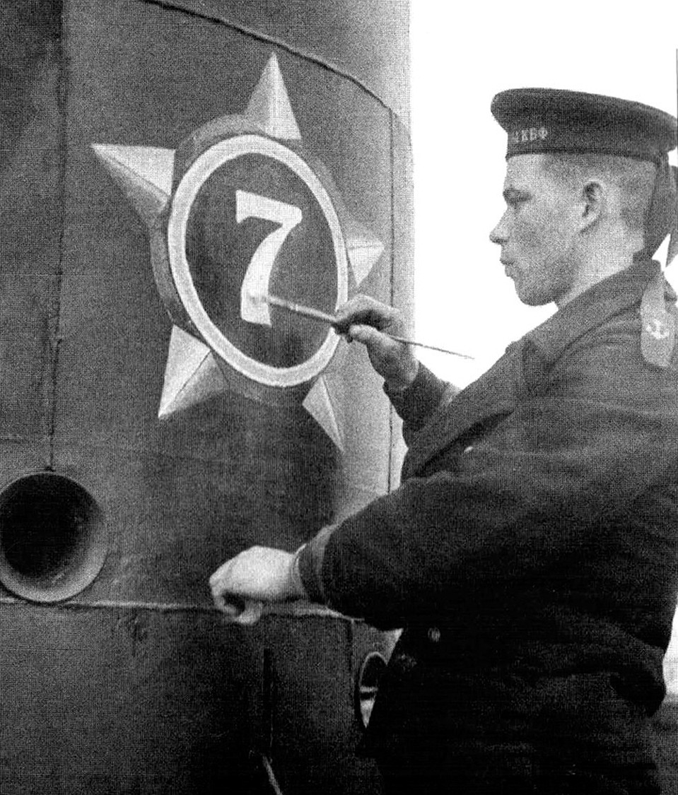 Матрос Борис Дядькин рисует на субмарине цифру "7" - по количеству потопленных вражеских кораблей.