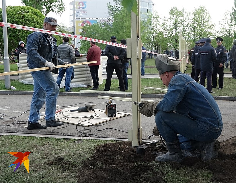 Установка нового забора на место временного под защитой людей в форме. Фото: Дмитрий СТЕШИН