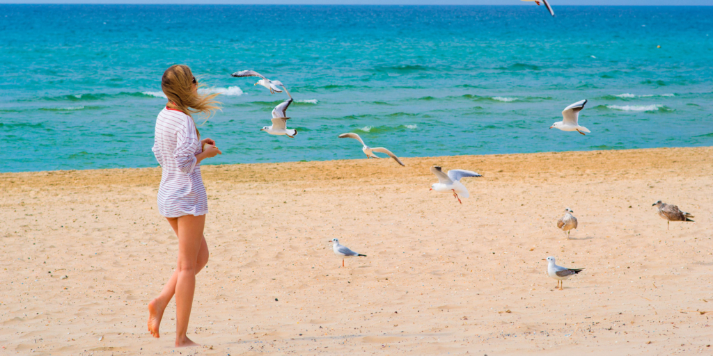 девушка на берегу моря с чайками